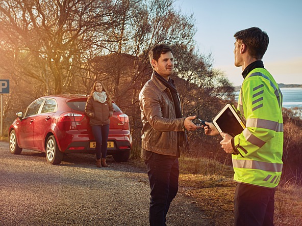 AA driver hands car keys to man next to car at the side of the road