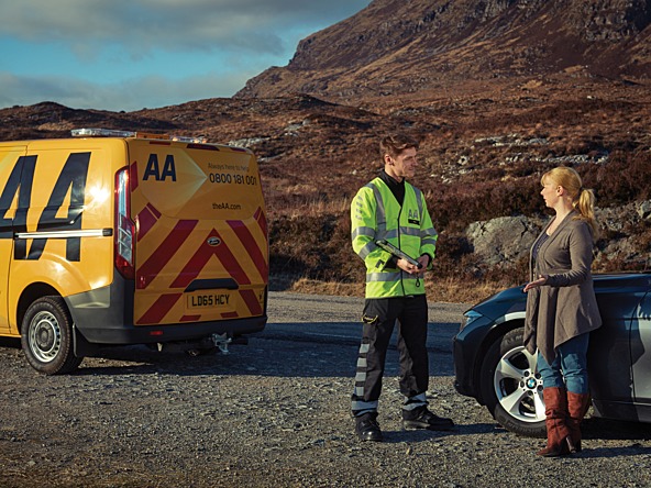 AA driver speaking to woman next to car at the side of a rural road