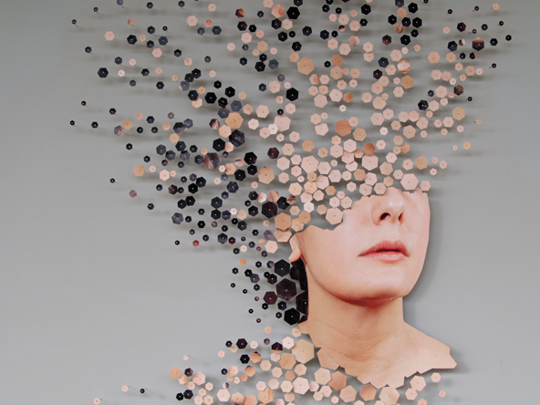 an image of a woman with the top of her head fragmenting into small hexagons