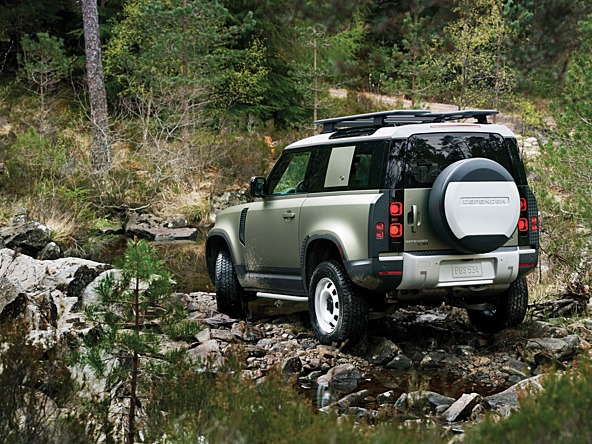 Land Rover off roading through forested area