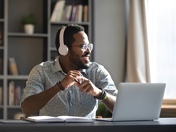 Man on laptop listening to headphones