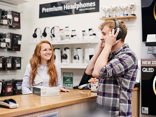two people in a shop listening to headphones