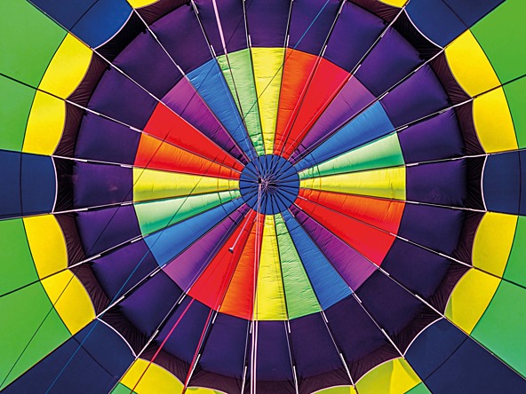 The view looking up into a multi-coloured hot air balloon