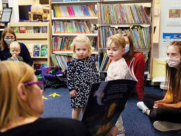 a woman reading young children a book